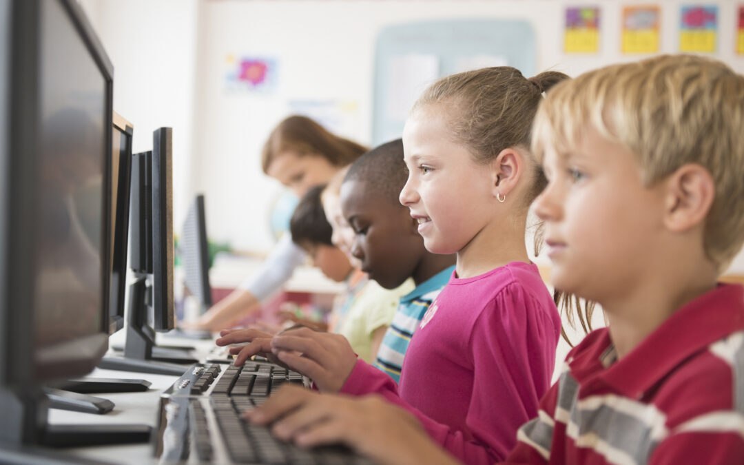 Children on computers at school practicing digital literacy skills