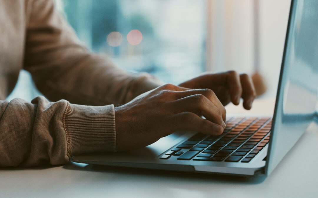 Closeup of adult on laptop at table