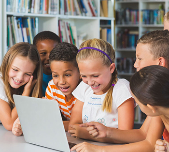 Two young female students thinking like programmers on a laptop in a classroom